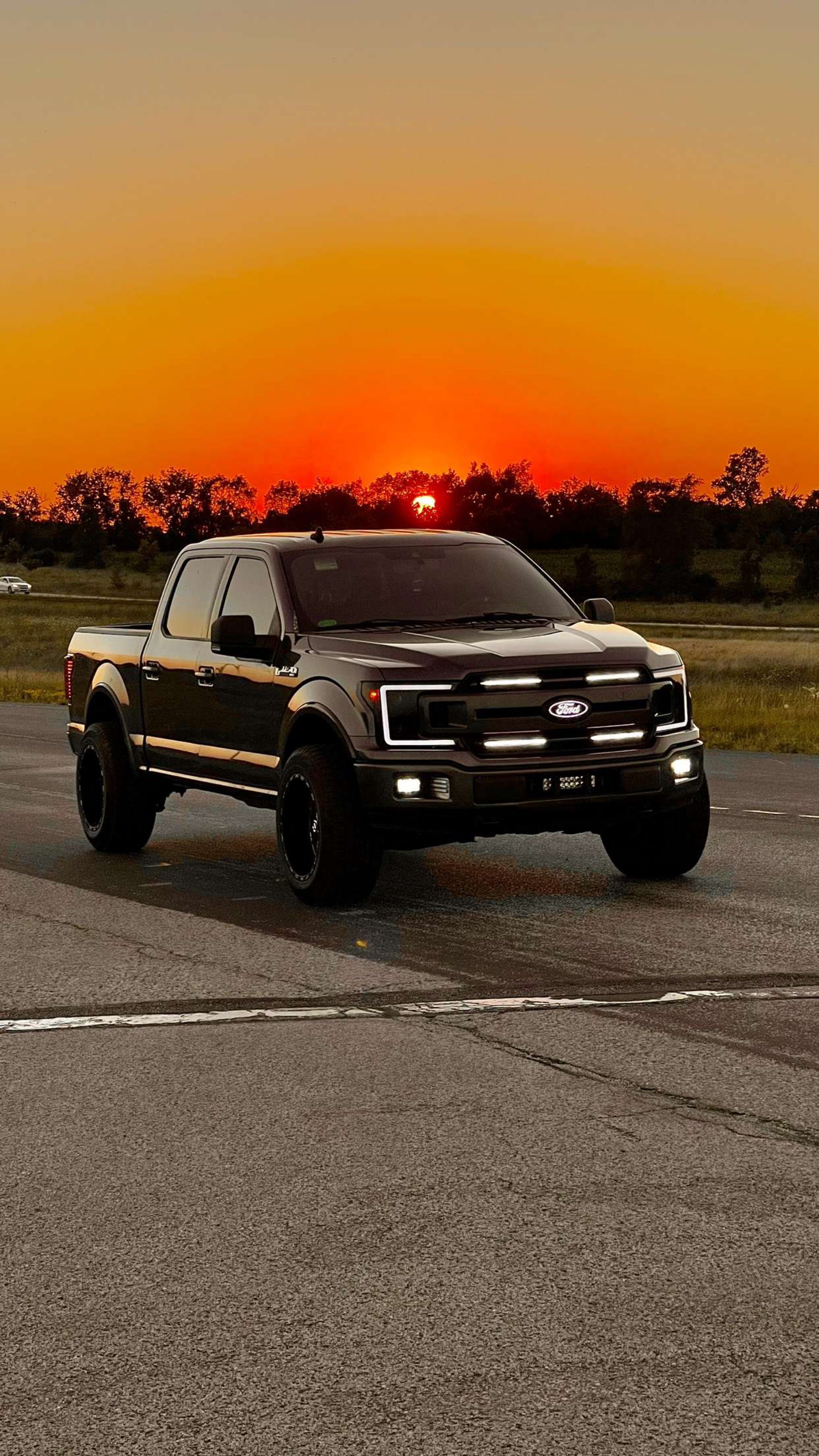 ford f150 with 4 bar grill lights and sunset in background